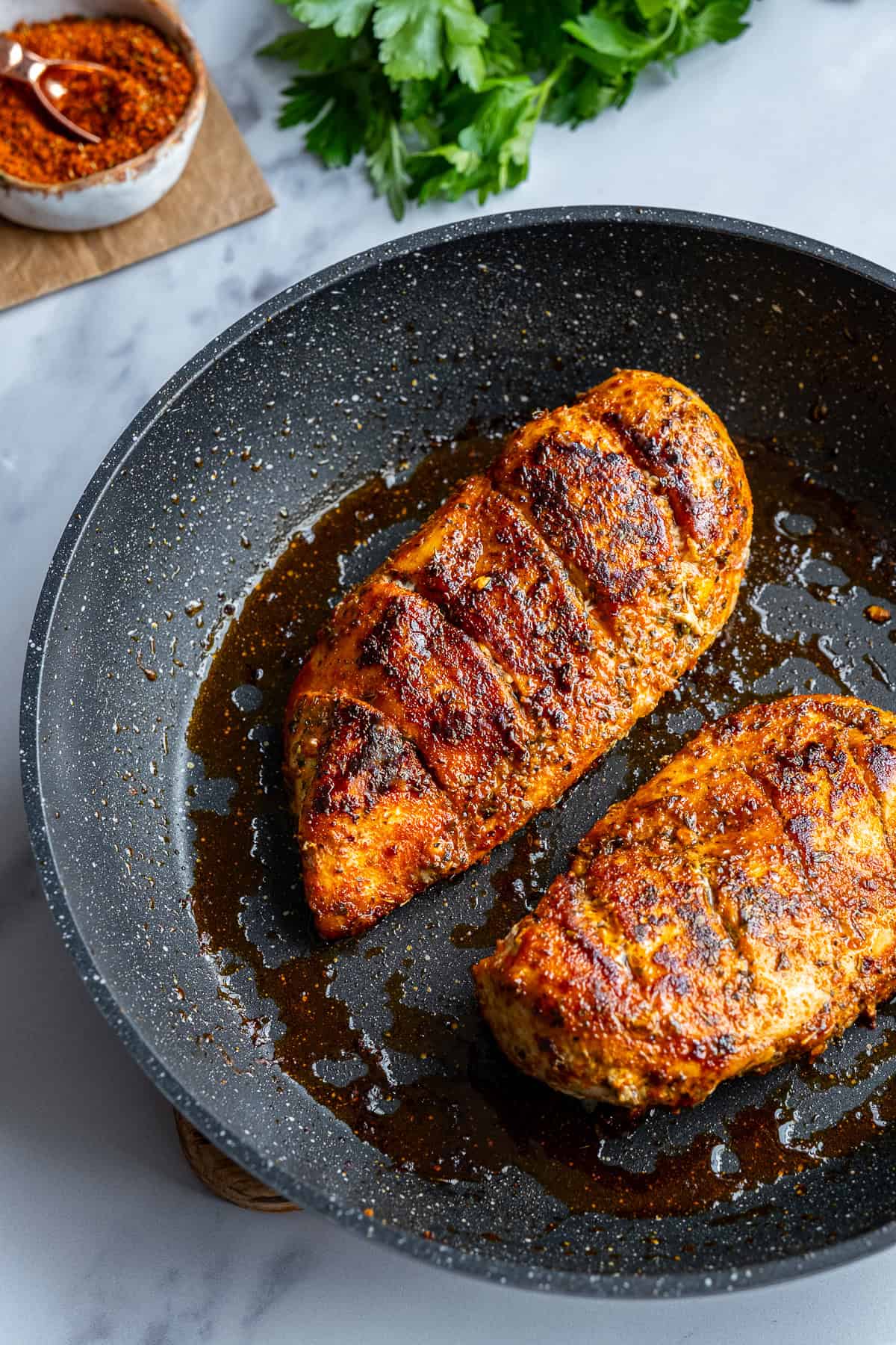 Pan-fried chicken breasts in a non-stick pan.