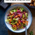 Lettuce salad with thinly sliced red cabbage and shredded carrot in a white bowl.