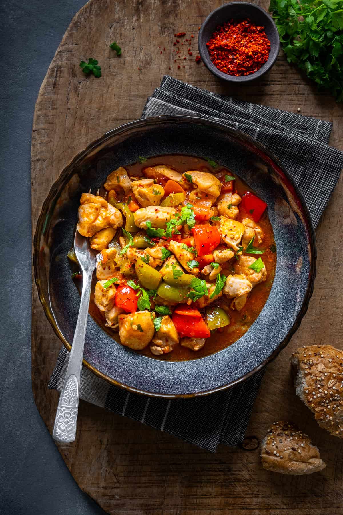 Turkish chicken dish with a tomato sauce served in a bowl and a fork inside it.