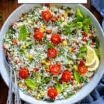 Turkish rice salad with cherry tomatoes, herbs, and lemon slices in a white bowl, with text overlay reading ‘Turkish Rice Salad – giverecipe.com’.