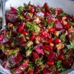 Close-up of Turkish beetroot salad with chopped beets, fresh dill, walnuts, and pomegranate arils.