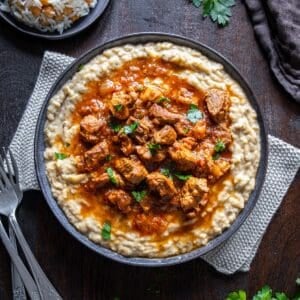 Hunkar Begendi with lamb stew served over creamy eggplant puree, garnished with parsley and served with rice.