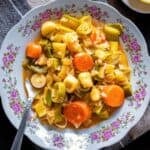 Pinterest-style image labeled “Turkish Leeks Zeytinyağlı Pırasa” showing braised leeks and carrots on a floral plate with lemon slices and kitchen towels on a dark background.