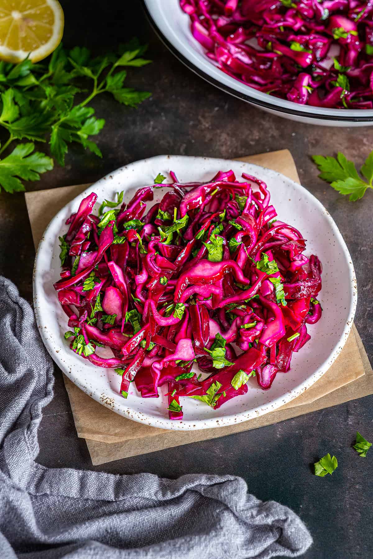 Turkish red cabbage salad with parsley served on a plate, bright pink and glossy.