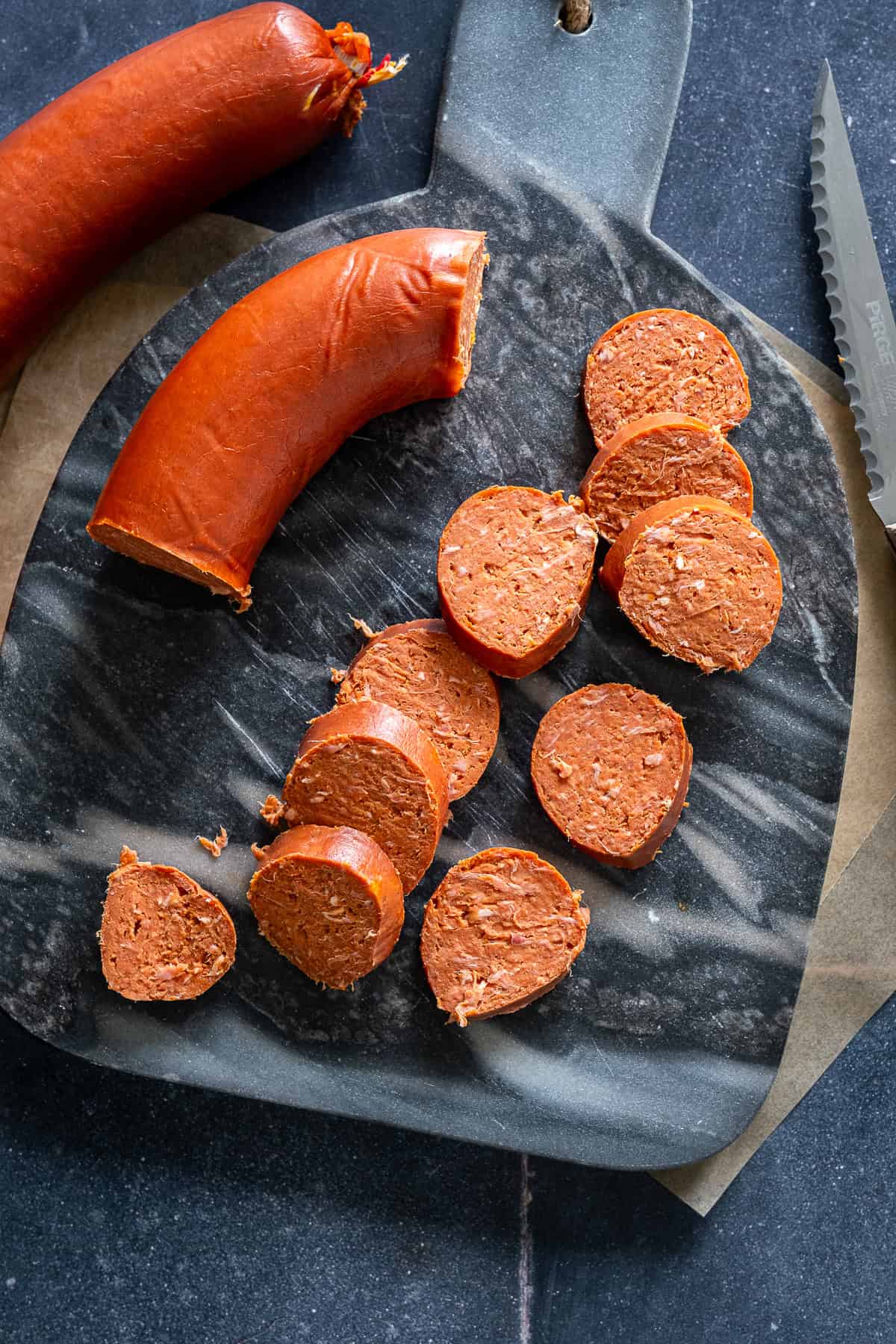Close-up of Turkish sucuk sausage sliced on a cutting board before cooking.
