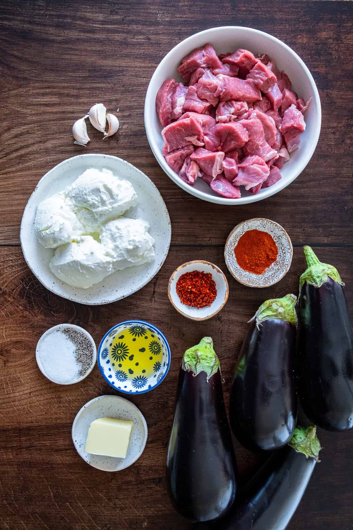 Ingredients for Ali Nazik Kebab including eggplants, lamb, strained yogurt, garlic, butter, olive oil, and spices.
