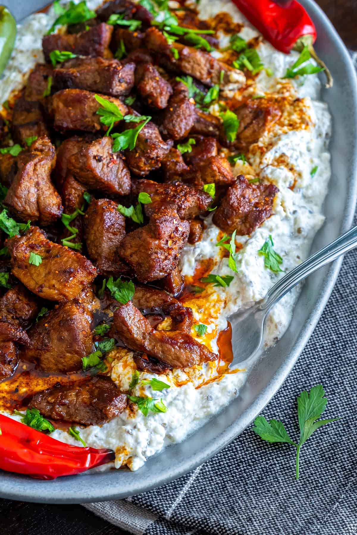 Close-up of Ali Nazik Kebab served on an oval plate and a fork tucked into the side.