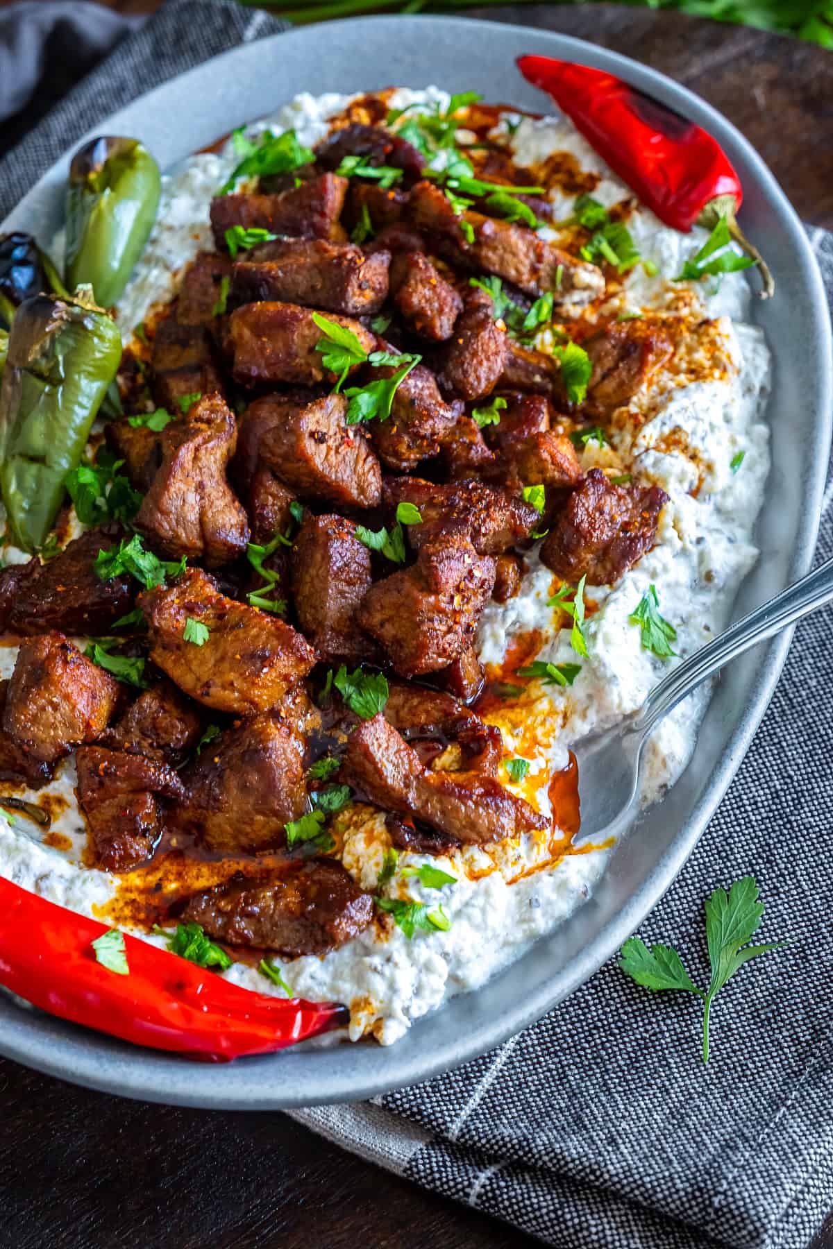 Ali Nazik Kebab served on a gray oval plate with a fork tucked into the side.
