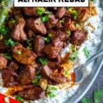Close-up of Ali Nazik Kebab served on a gray oval plate with roasted peppers and a fork tucked into the side.